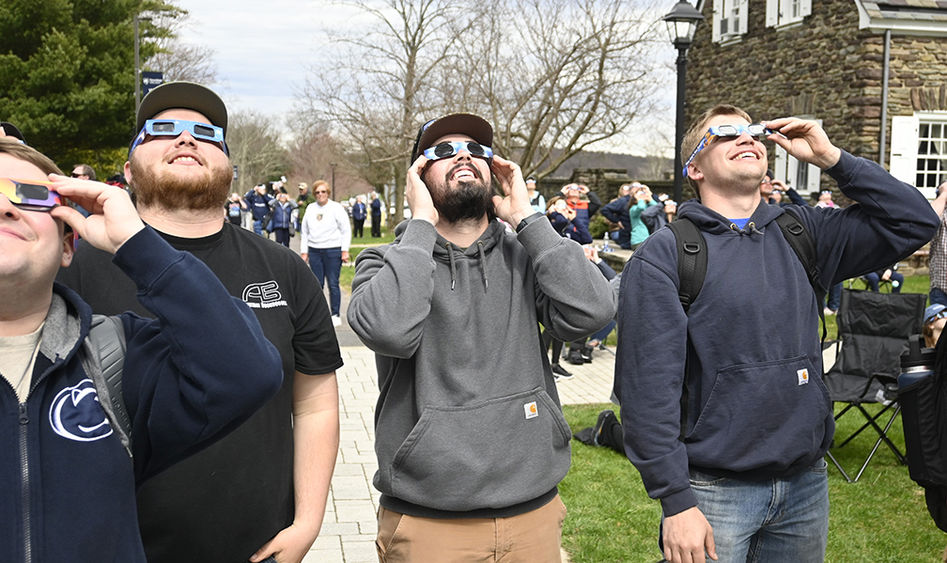 People wearing special glasses while looking at the sky.